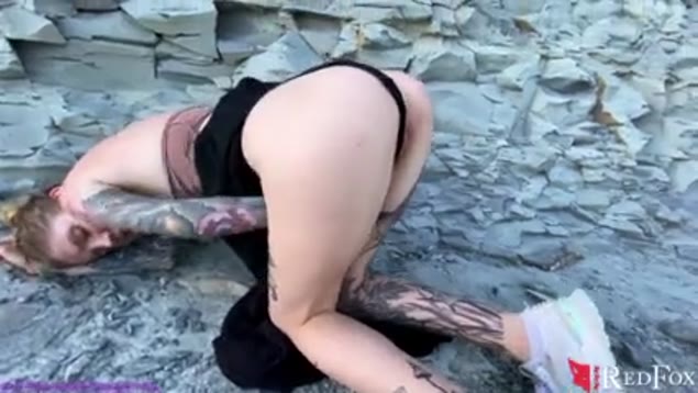 Getatoeëerde slet speelt met haar kutje bij de rotsen – hopelijk ziet niemand het